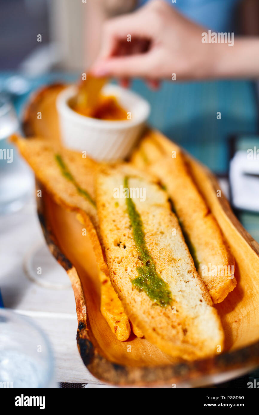 Crispy white bread baguette topped with pesto served for snack or appetizer at restaurant Stock Photo