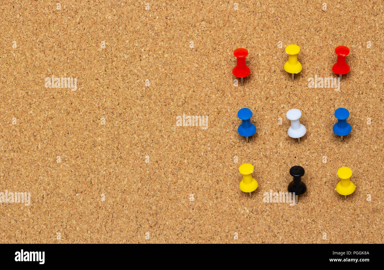 Nine colored pinned button on a cork board Stock Photo