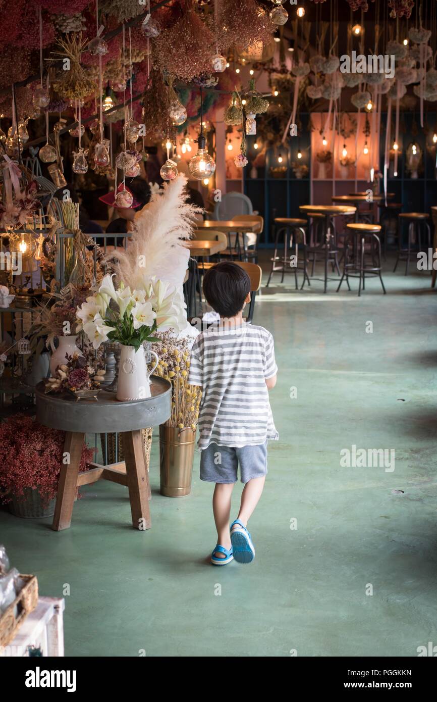 A curious kid is walking to decorated illumination in flower cafe, Korea Stock Photo