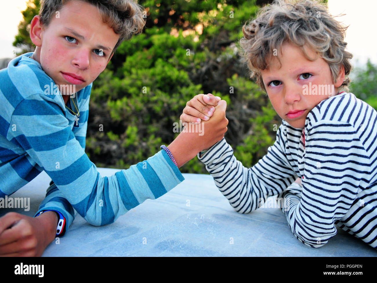 Caucasian brothers arm wrestling hires stock photography and images