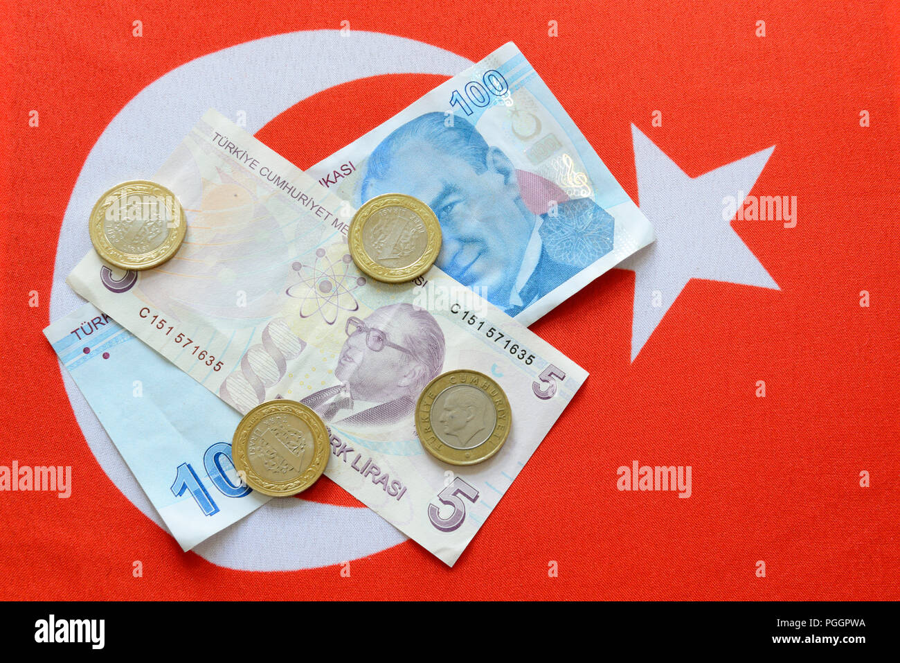 Turkish Lira bills and coins on turkish flag. The Turkish Lira is the national currency of Turkey Stock Photo
