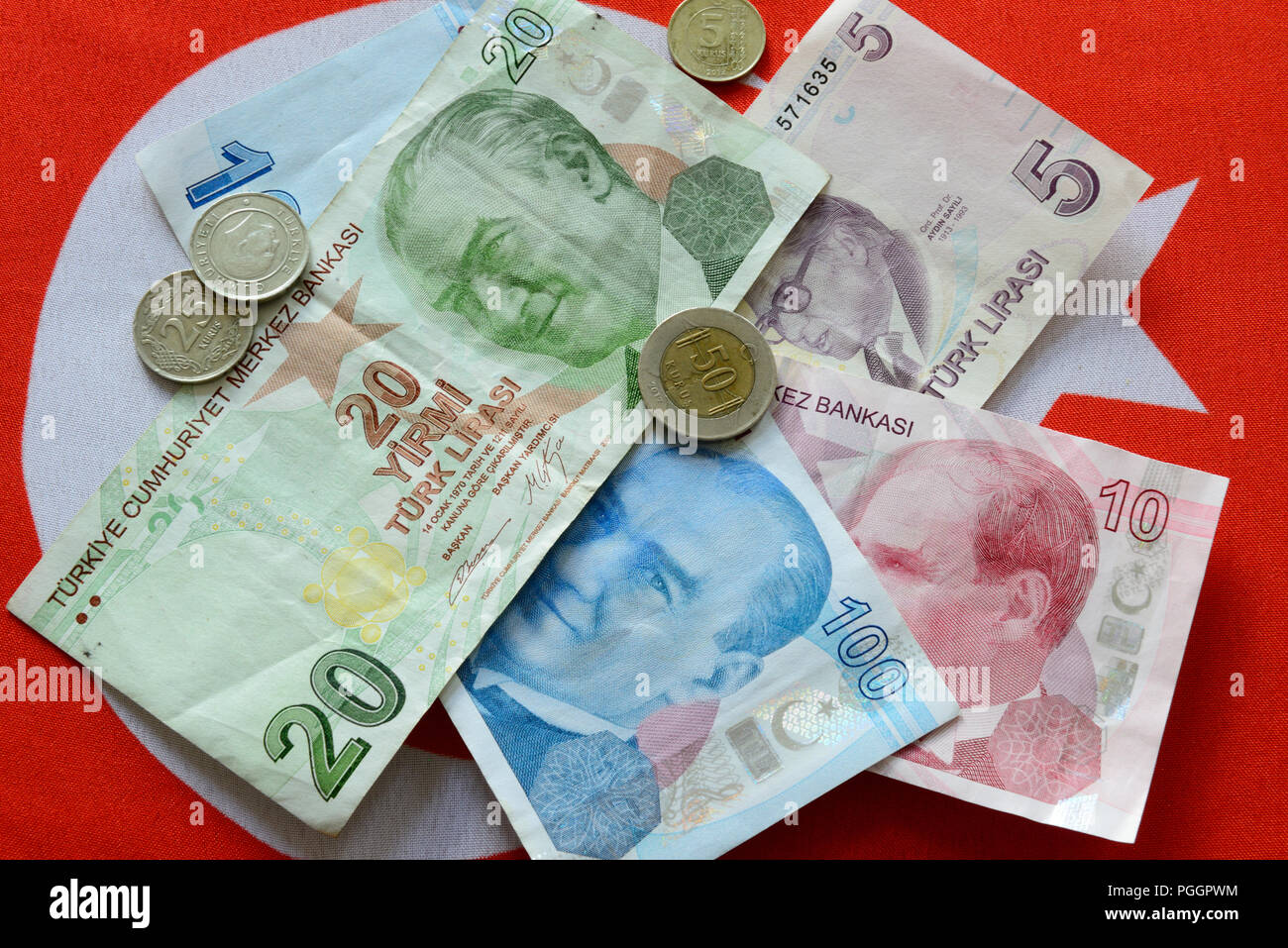 Turkish Lira bills and coins on turkish flag. The Turkish Lira is the