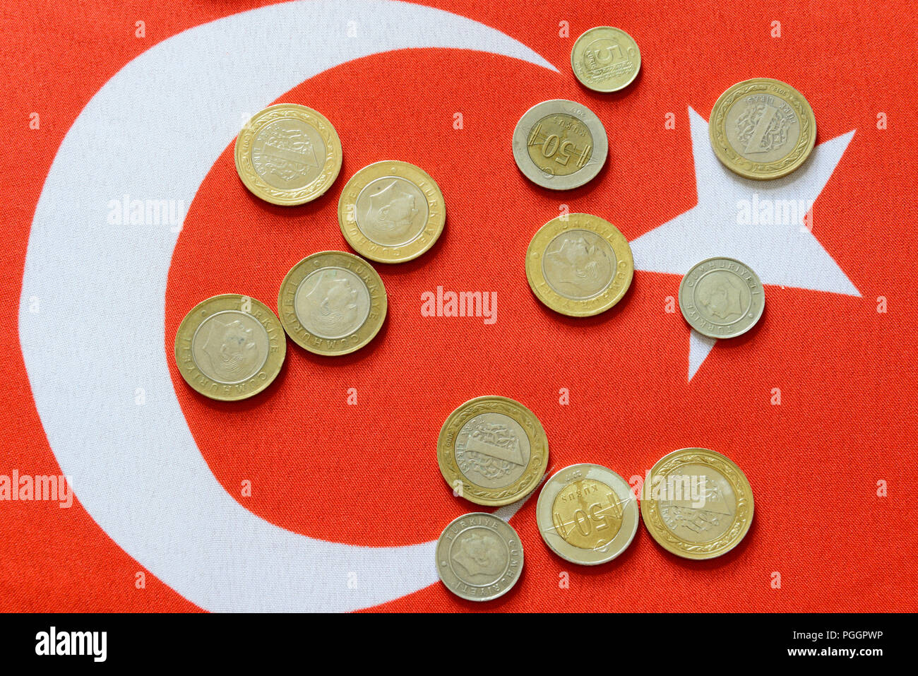 Turkish Lira bills and coins on turkish flag. The Turkish Lira is the national currency of Turkey Stock Photo