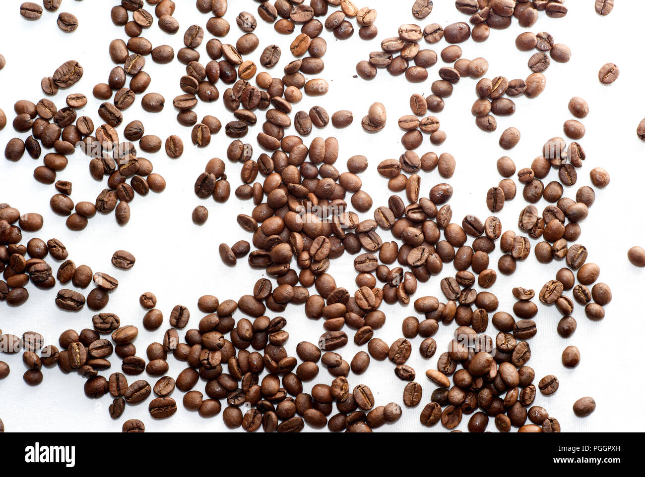 Scattered Brown Coffee Beans on White Background Stock Photo