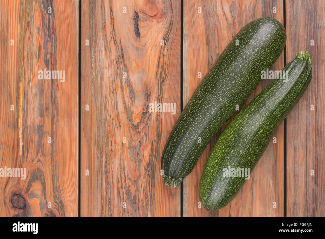 Squash, zucchini black beauty organic. Top view. Brown wooden desk background. Stock Photo