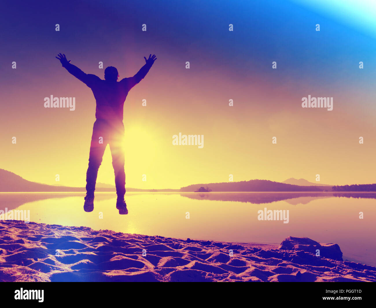 Sportsman doing stretching in the park. Silhouette against sun, sports concept.  Hipster filter. Stock Photo