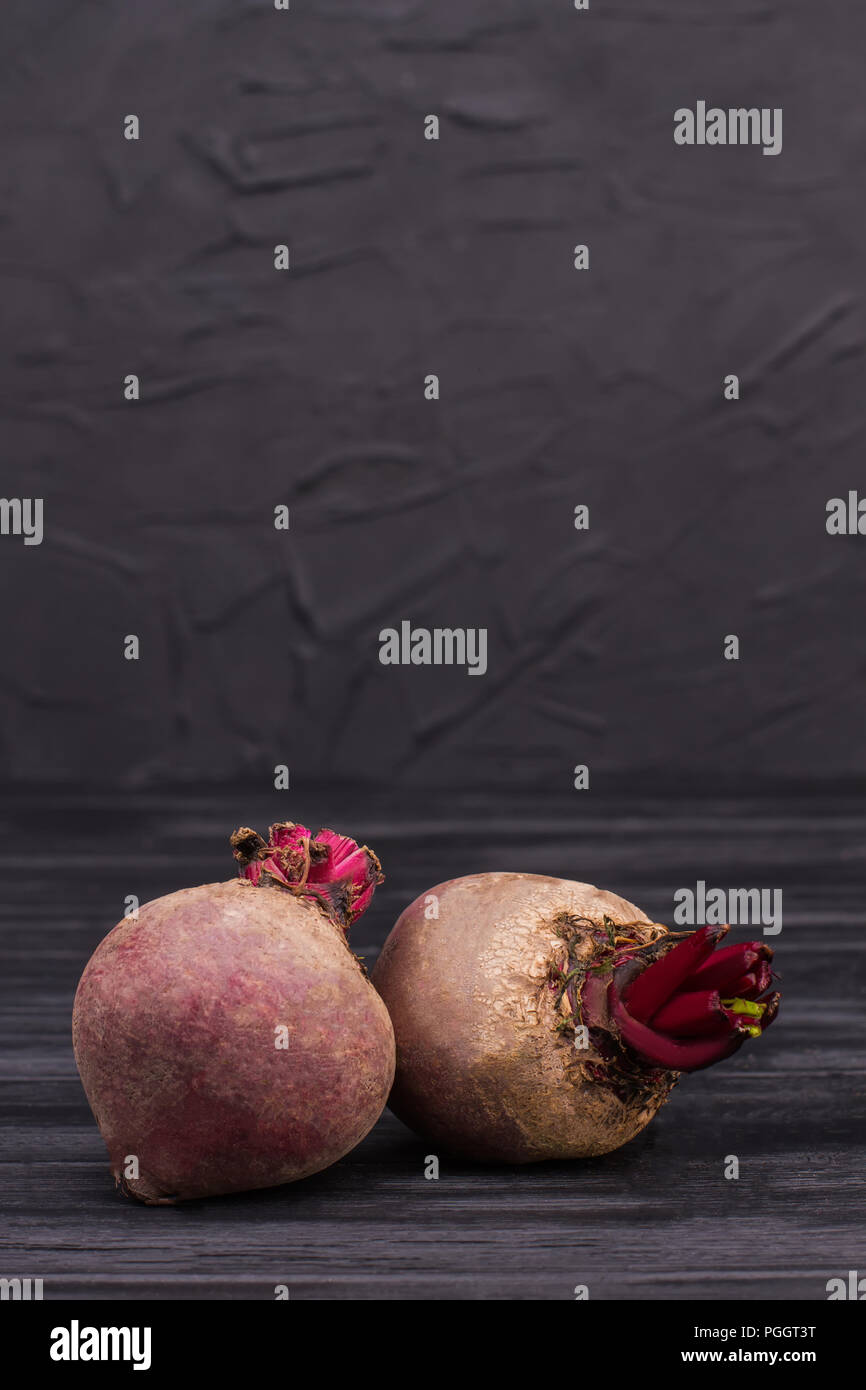 Two beetroots over black background. Raw fresh beetroots on dark wood. Stock Photo