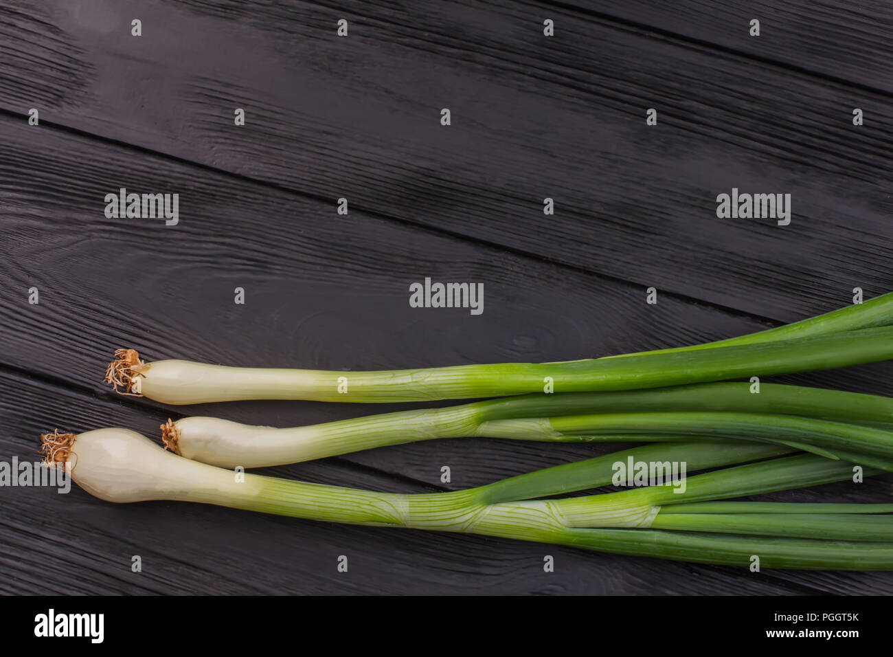 Bunch of ripe organic green onion. Dark wooden background Stock Photo ...