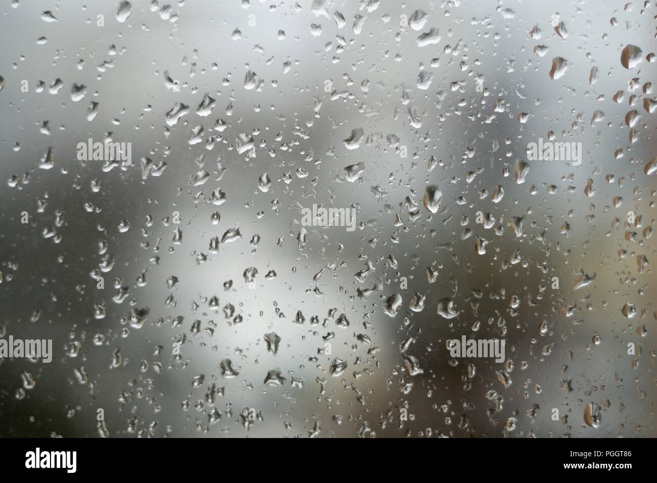 Raindrops on window, rainy weather. Abstract grey background, texture of rain drops on glass Stock Photo