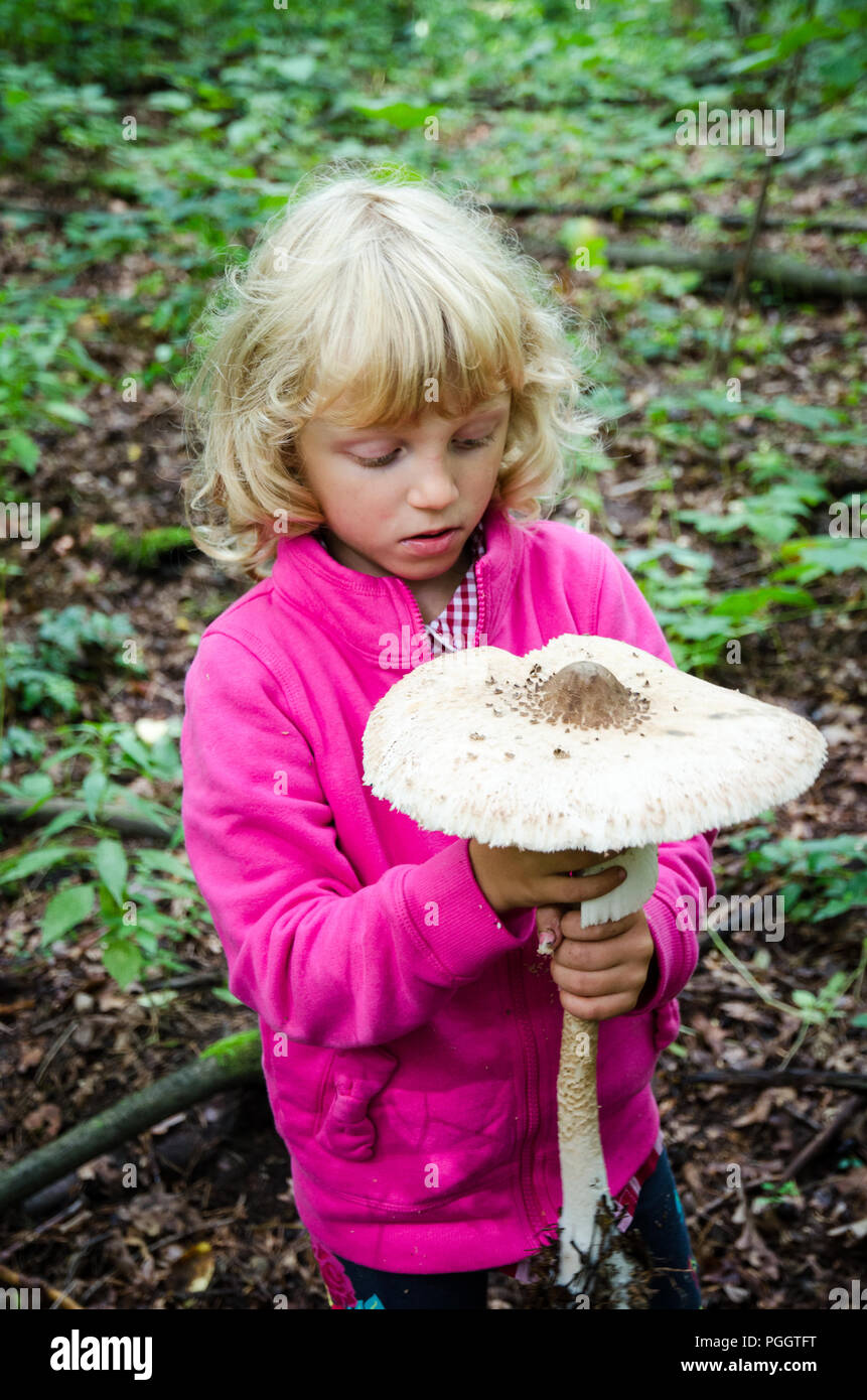 girl with giant parasol mushroom at autumn time Stock Photo