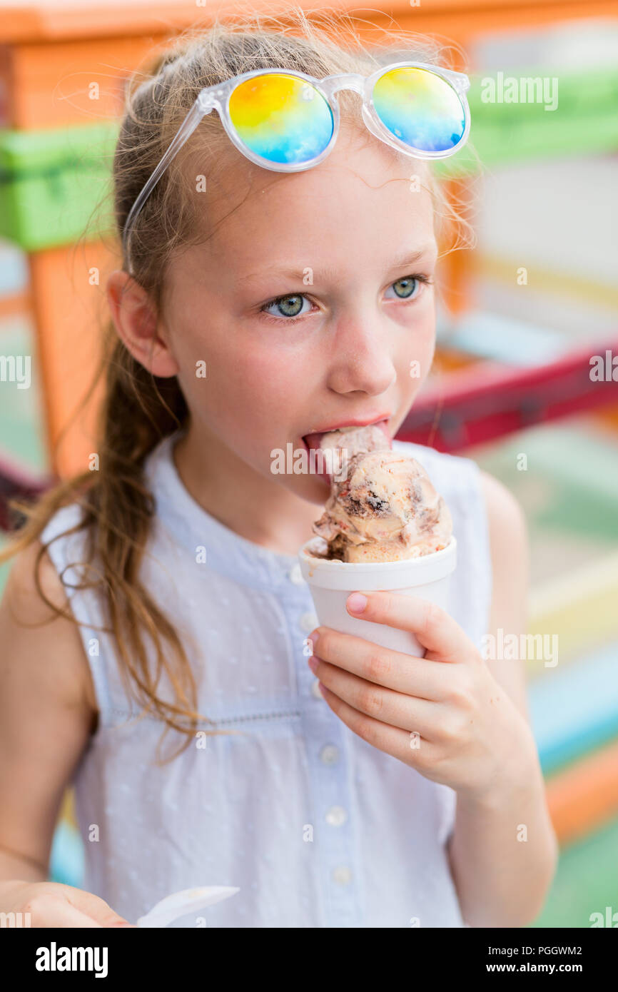 Adorable girl eating chocolate ice cream outdoors on summer day Stock