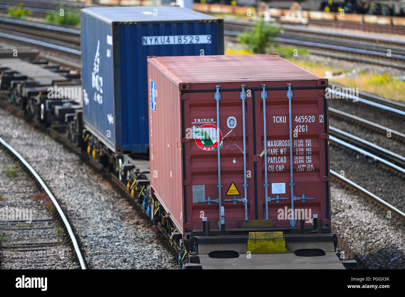 Container railway train travelling  on the main line into Southampton and Southampton Docks carring goods for export and import. Stock Photo