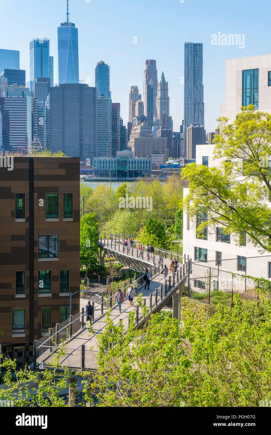 People walking on an walkway towards the Brooklyn Bridge Park in New York City Stock Photo