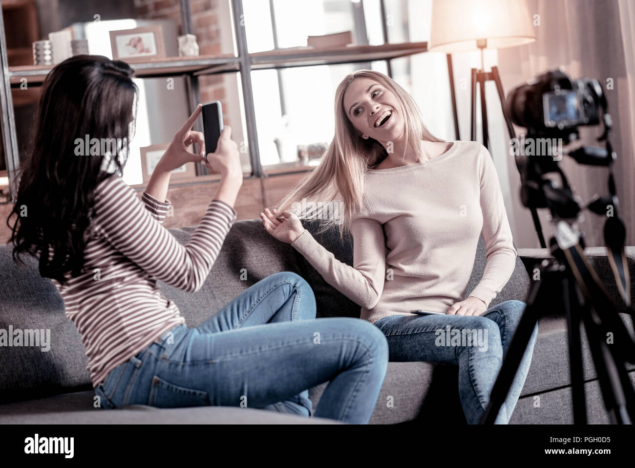 Concentrated woman photographing her friend Stock Photo