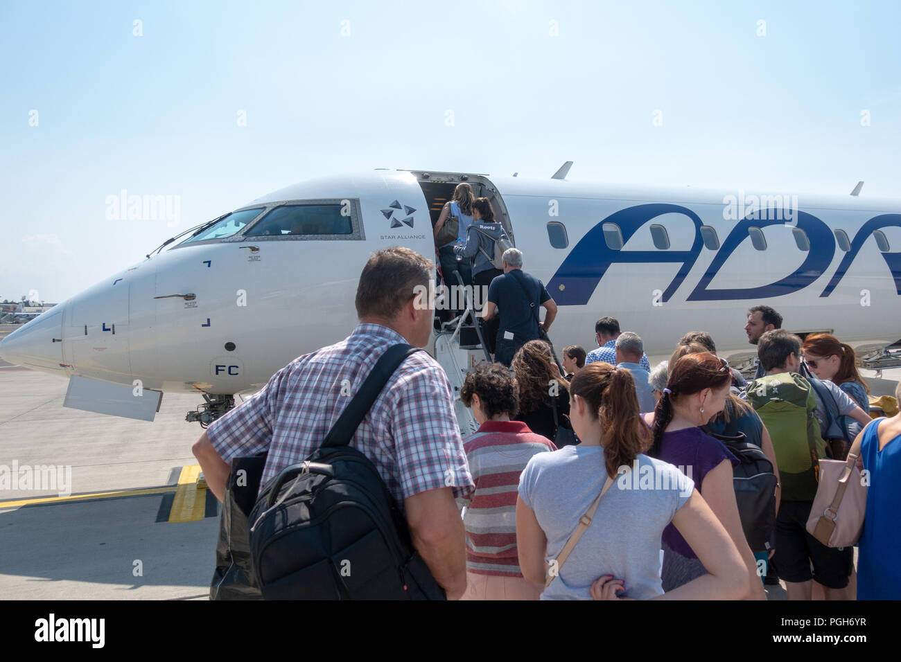 Ljubljana, Slovenia - August 25 2018: Passengers board Adria Airways Bombardier CRJ-900 passenger jet at Ljubljana Airport to SKopje. Adria is local c Stock Photo