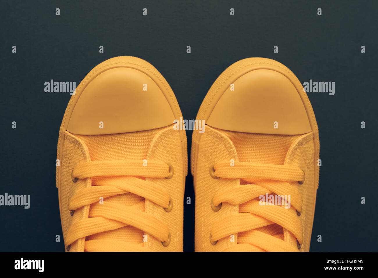 Stylish yellow sneakers from above, young person unisex style and fashion concept with copy space, top view Stock Photo
