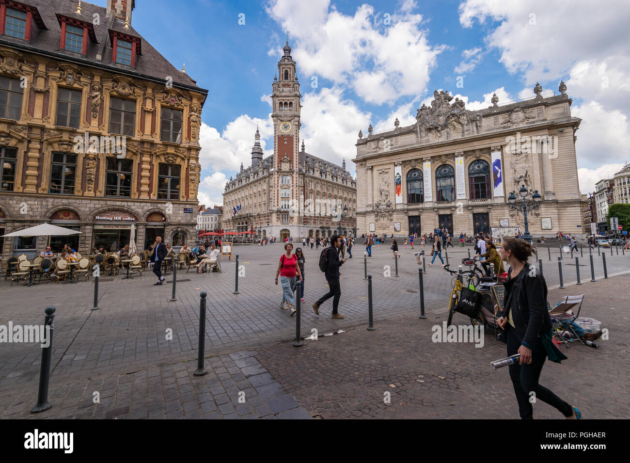 Lille, France - 15 June 2018: People walking in the Theatre Square. Belfry of the Chambre de Commerce and Opera House in the background. Stock Photo