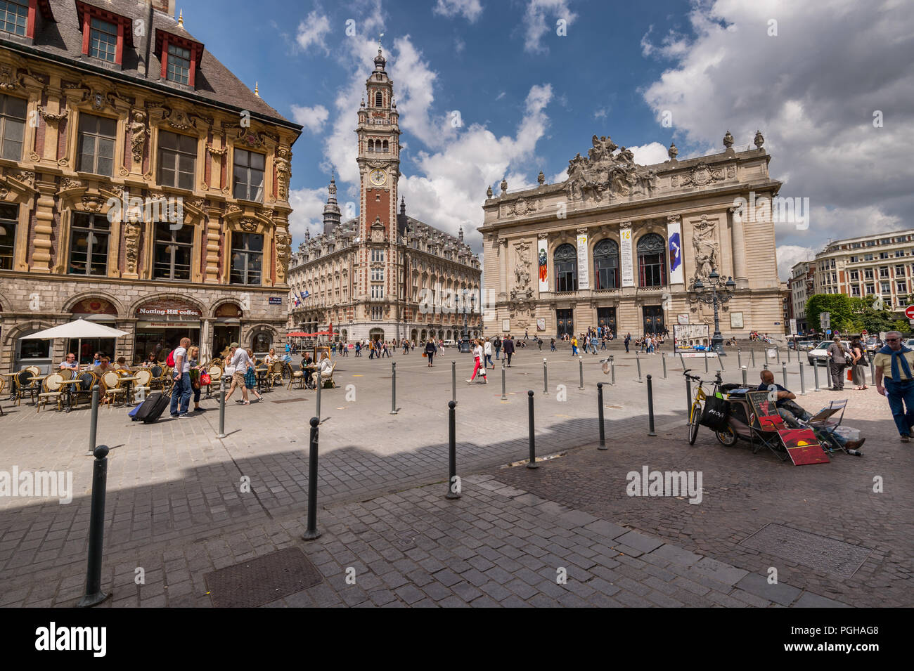 Lille, France - 15 June 2018: People walking in the Theatre Square. Belfry of the Chambre de Commerce and Opera House in the background. Stock Photo