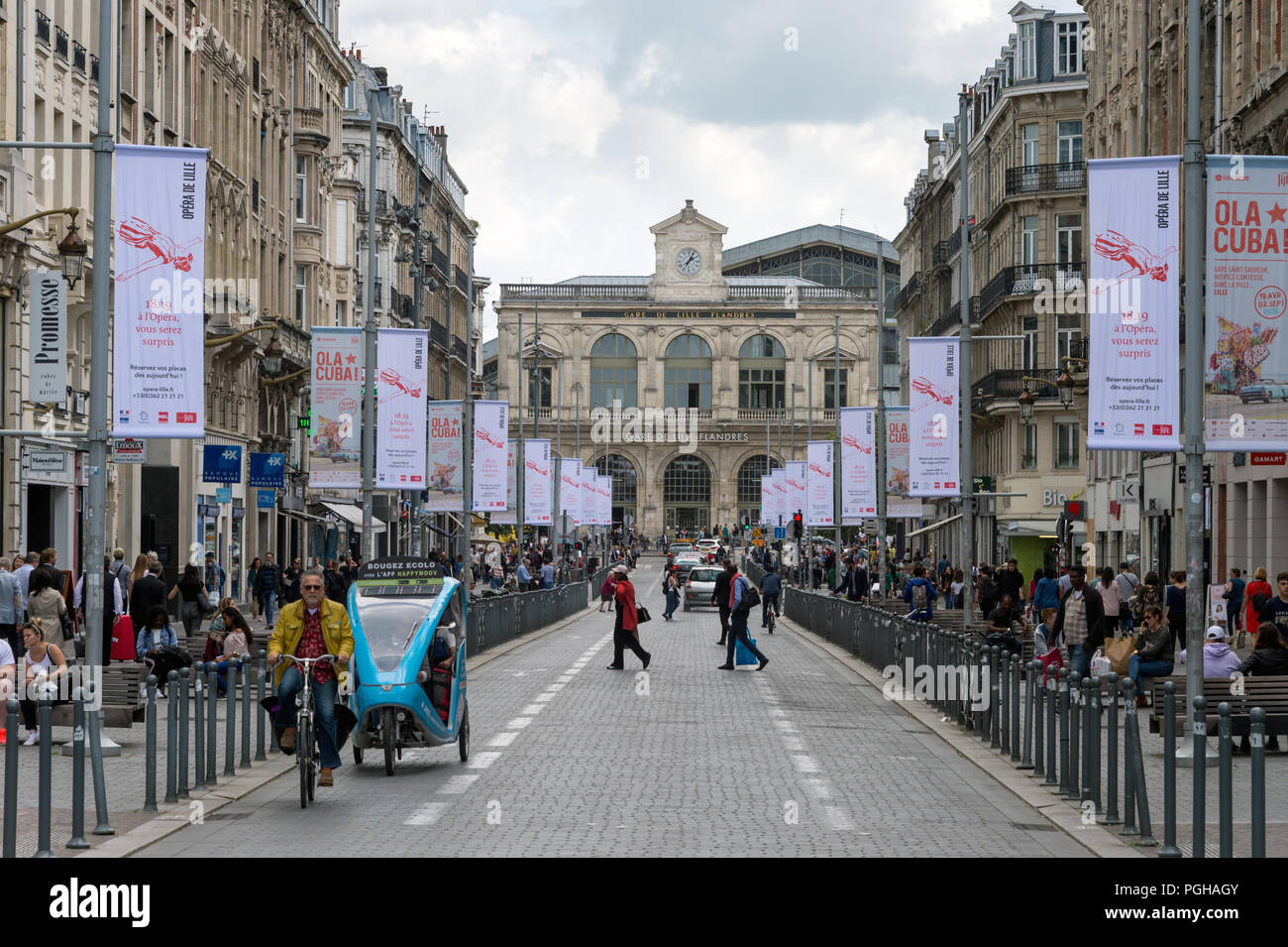 Lille, France - 15 June 2018: Traffic and people walking on Faidherbe street. Lille-Flandres railroad station the background. Stock Photo