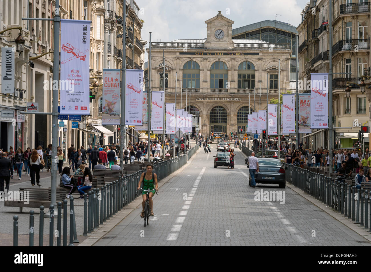 Lille, France - 15 June 2018: Traffic and people walking on Faidherbe street. Lille-Flandres railroad station the background. Stock Photo