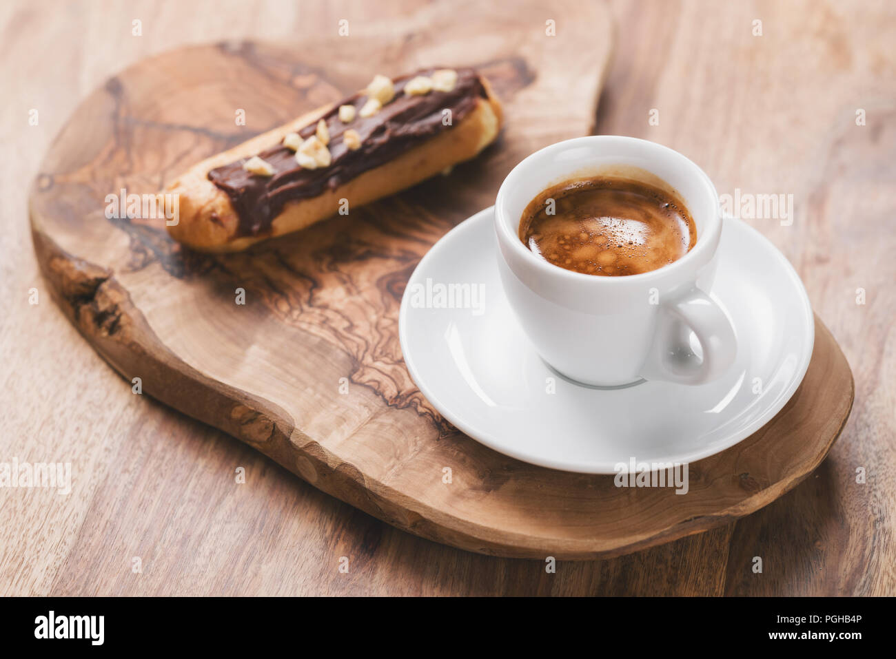 espresso with eclair on wooden board, breakfast Stock Photo