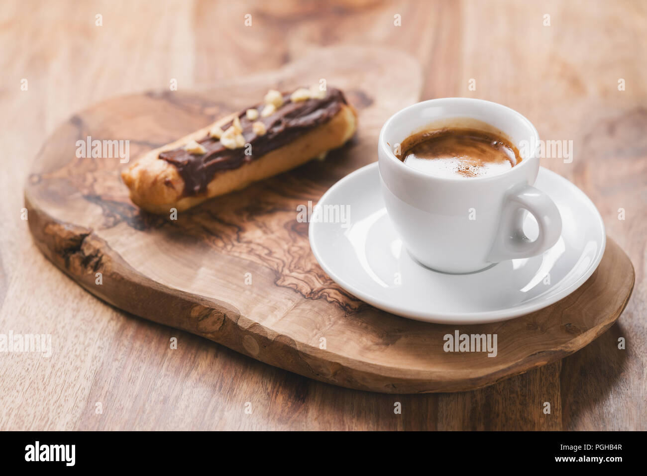 espresso with eclair on wooden board, breakfast Stock Photo