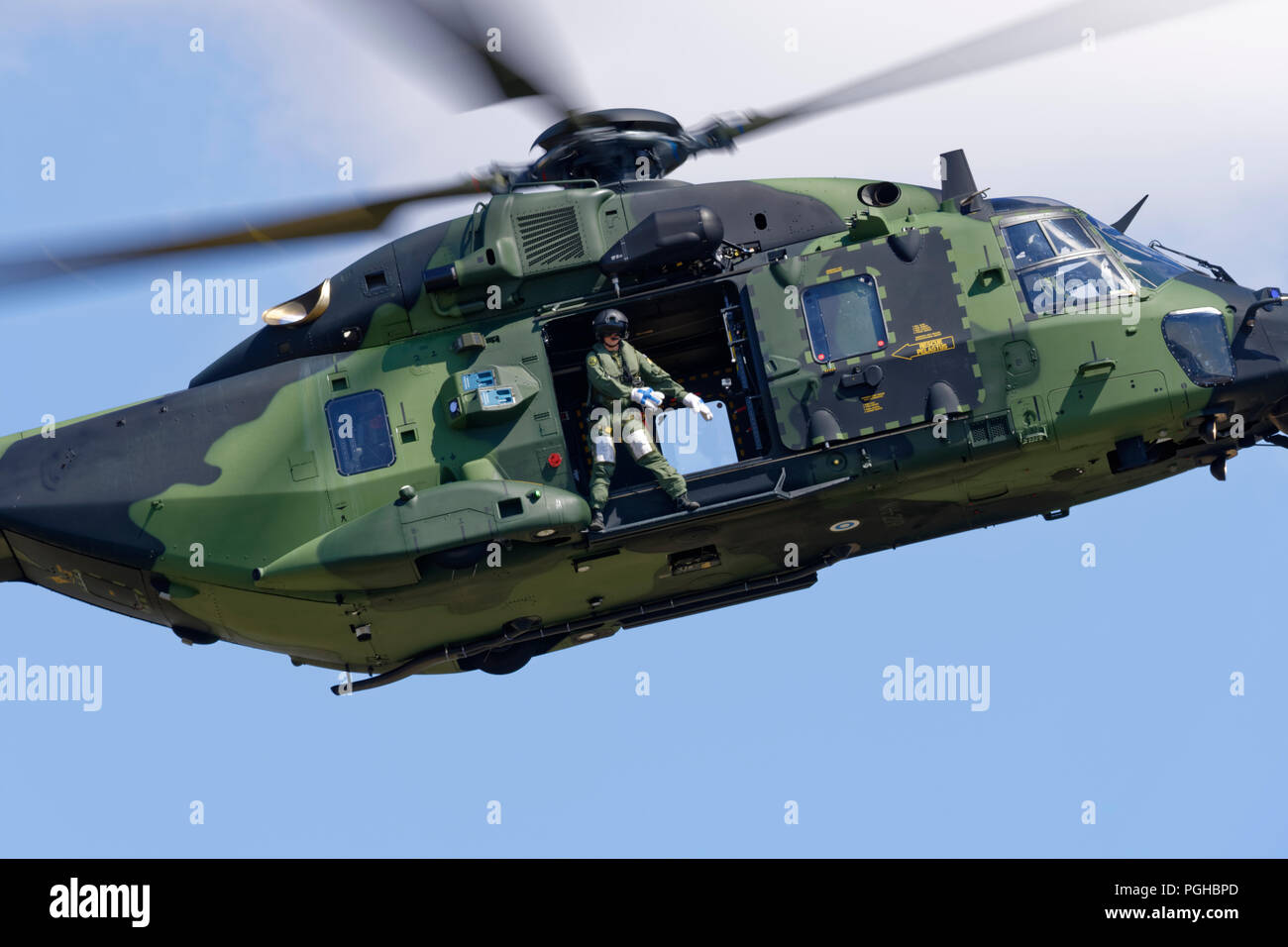 Finnish Army NH90 helicopter crewman demonstrates The Floss Dance while hovering over the display line at the Royal International Air Tattoo Stock Photo