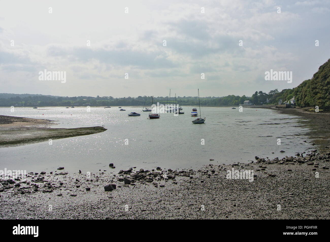 Red wharf bay at low tide on the beautiful Welsh island of Anglesey.  Small boats on the sandbanks at low tide .  Copy space, Stock Photo