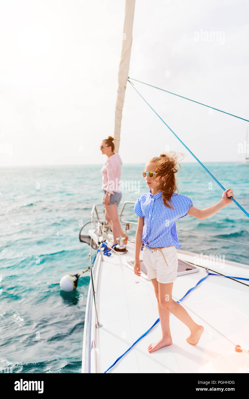 Family of mother and daughter on board of sailing yacht having summer travel adventure Stock Photo
