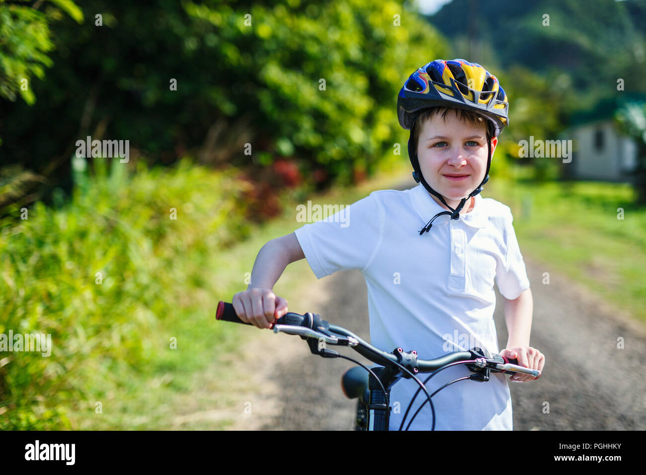 Teenager boy biking at tropical settings having fun Stock Photo