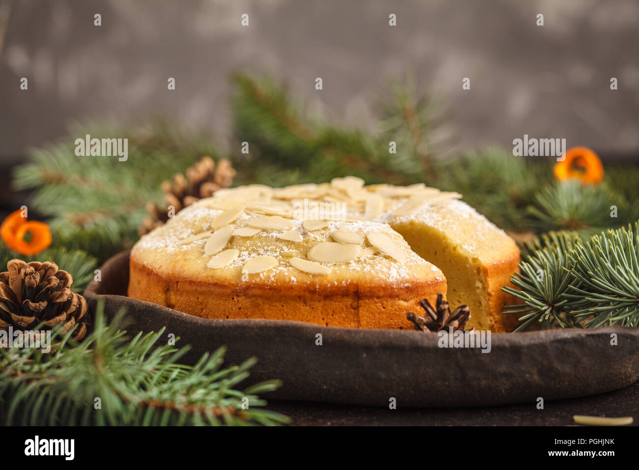 Traditional Christmas (Norwegian) almond cake in Christmas decorations, dark background