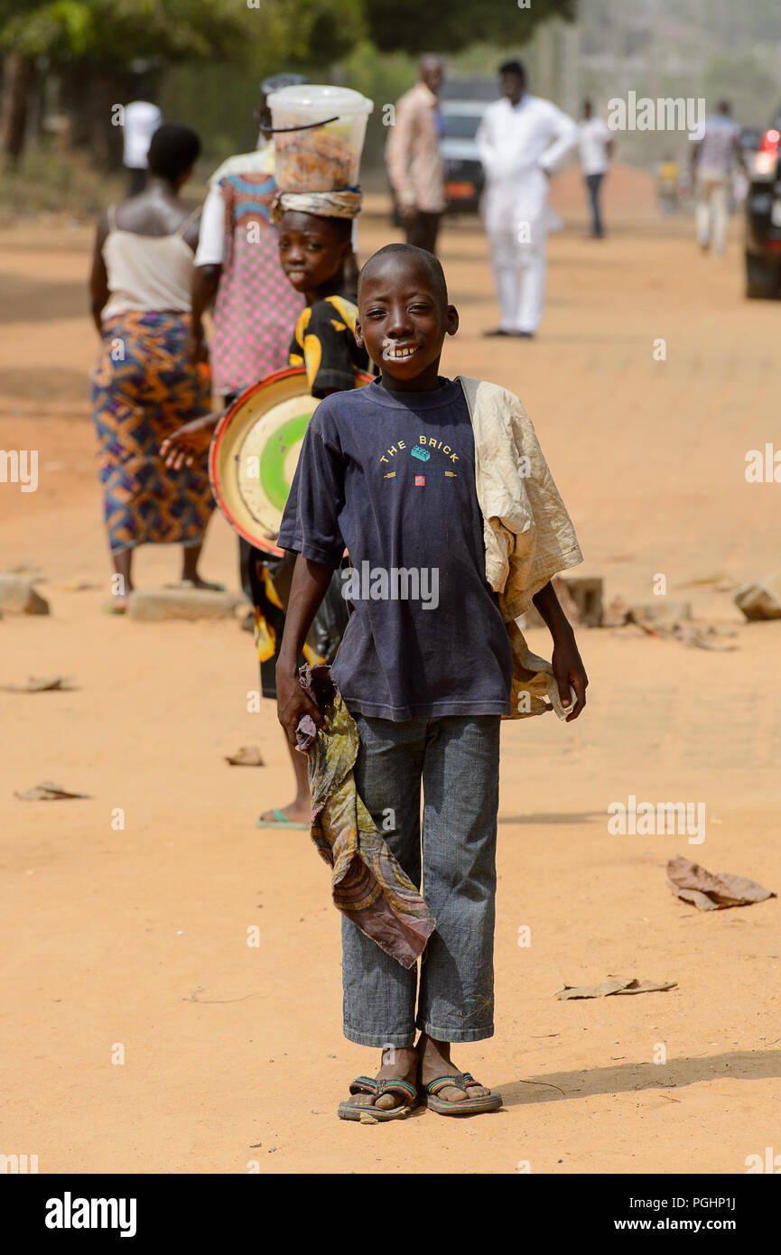 OUIDAH, BENIN - Jan 10, 2017: Unidentified Beninese young boy holds some clothes in his hand. Benin children suffer of poverty due to the bad economy Stock Photo