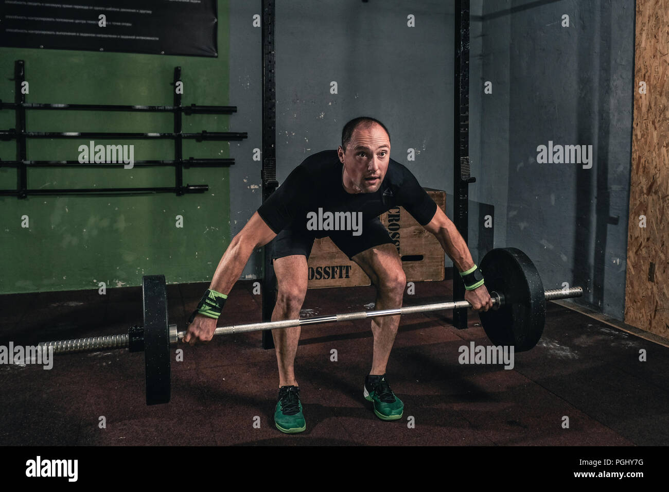 Young man at a crossfit gym lifting a barbell. Stock Photo