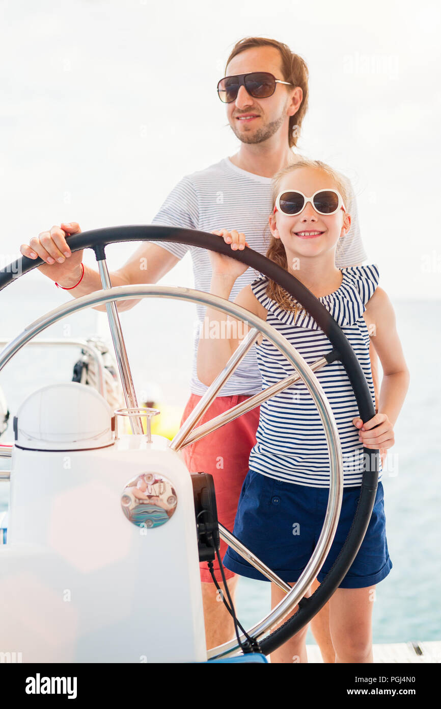 Father and daughter on board of sailing yacht having summer travel