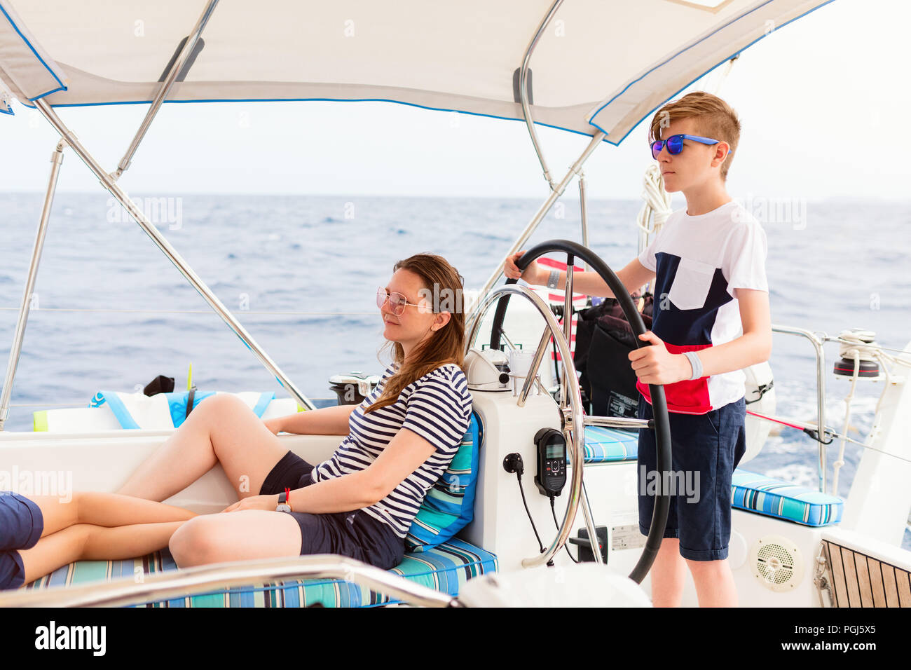 Family of mother and son on board of sailing yacht having summer travel adventure Stock Photo