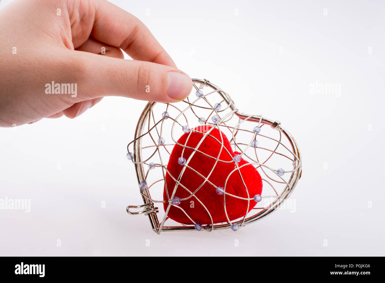 Red heart in a heart shaped cage Stock Photo Alamy