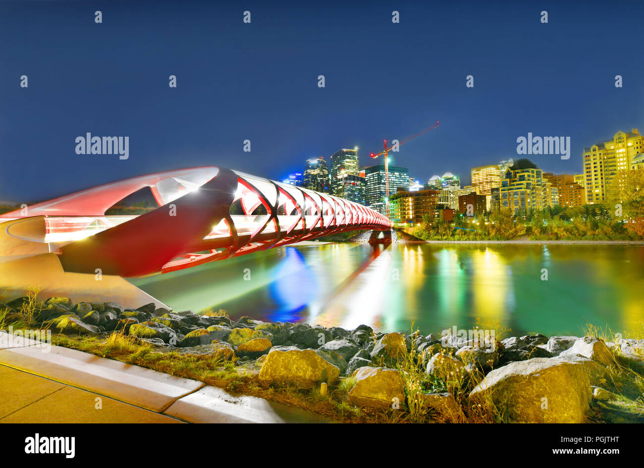 Peace Bridge with Bow River and part of the Calgary downtown in Alberta Canada at night Stock Photo
