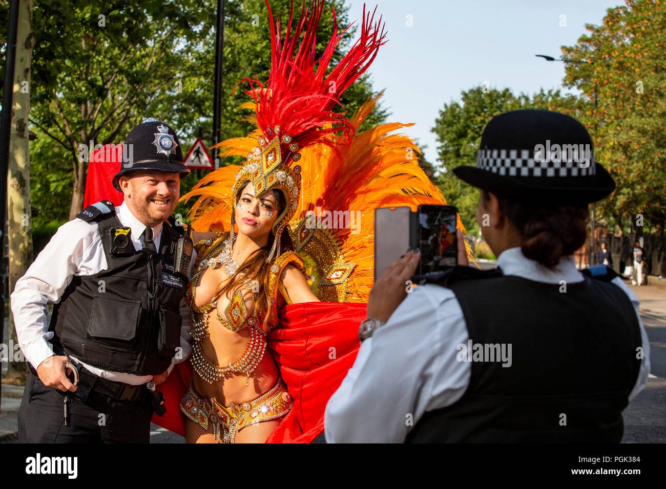 London, United Kingdom. 27 August 2018. A dancer from the Paraiso School of Samba poses with police constable Gary Hitchman from the Metropolitian Police before the parade at Notting Hill Carnival, Europe's largest street party.  Photo: Bettina Strenske/Alamy Live News Stock Photo