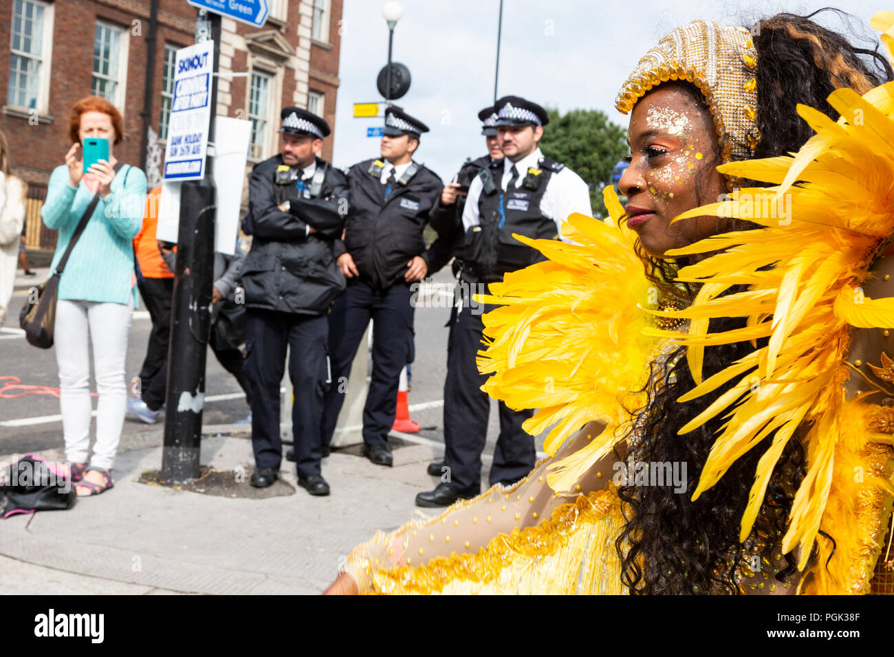 London, United Kingdom. 27 August 2018. Dancer and police officers at Notting Hill Carnival, Europe's largest street party.  Photo: Bettina Strenske/Alamy Live News Stock Photo