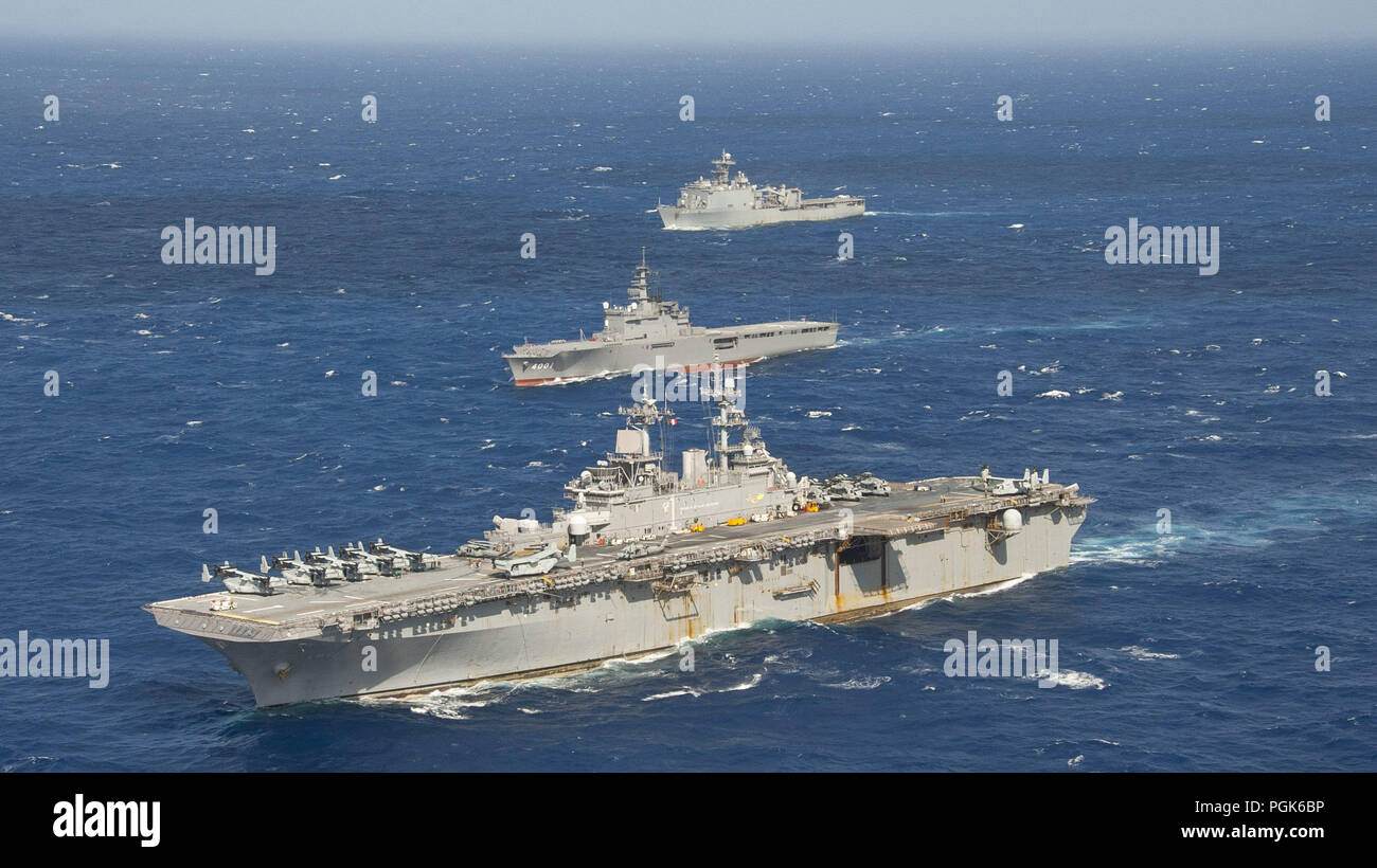 Philippine Sea. 25th Aug, 2018. PHILIPPINE SEA (Aug. 26, 2018) The amphibious assault ship USS Wasp (LHD 1) and the amphibious dock landing ship USS Ashland (LSD 48), both a part of the Wasp Amphibious Ready Group (ARG), are underway alongside the Japan Maritime Self-Defense Force (JMSDF) amphibious transport dock ship JS Osumi (LST 4001) during a passing exercise (PASSEX) in the Philippine Sea, Aug. 26, 2018. PASSEX enabled the Wasp ARG and the JMSDF a chance to practice communications and maneuvering procedures. The Wasp ARG is currently operating in the region to enhance interoperability Stock Photo