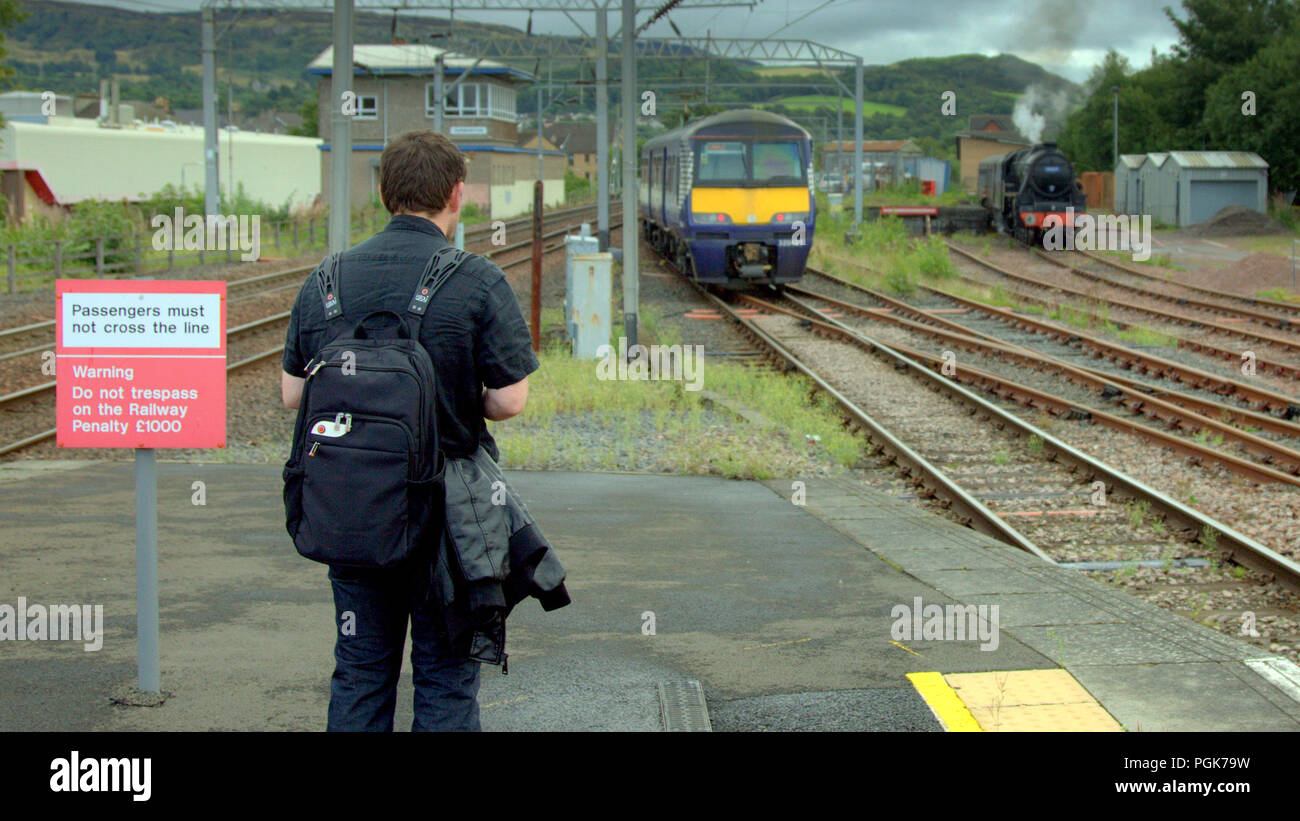 Glasgow, Scotland, UK. 27th  August, 2018. Locals where treated to a bit of living history as The Glasgow Highlander steam locomotive  spent overnight  taking on water and cleaning its firebox  in a siding at Dunbarton central before heading North to the touristic highland line as a replacement being relieved  of its duty in the borders Tweedbank line. Gerard Ferry/Alamy news Stock Photo