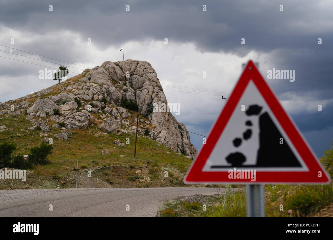Falling Roadside Rocks Falling rocks of landslide road sign and rocky hill in background ...