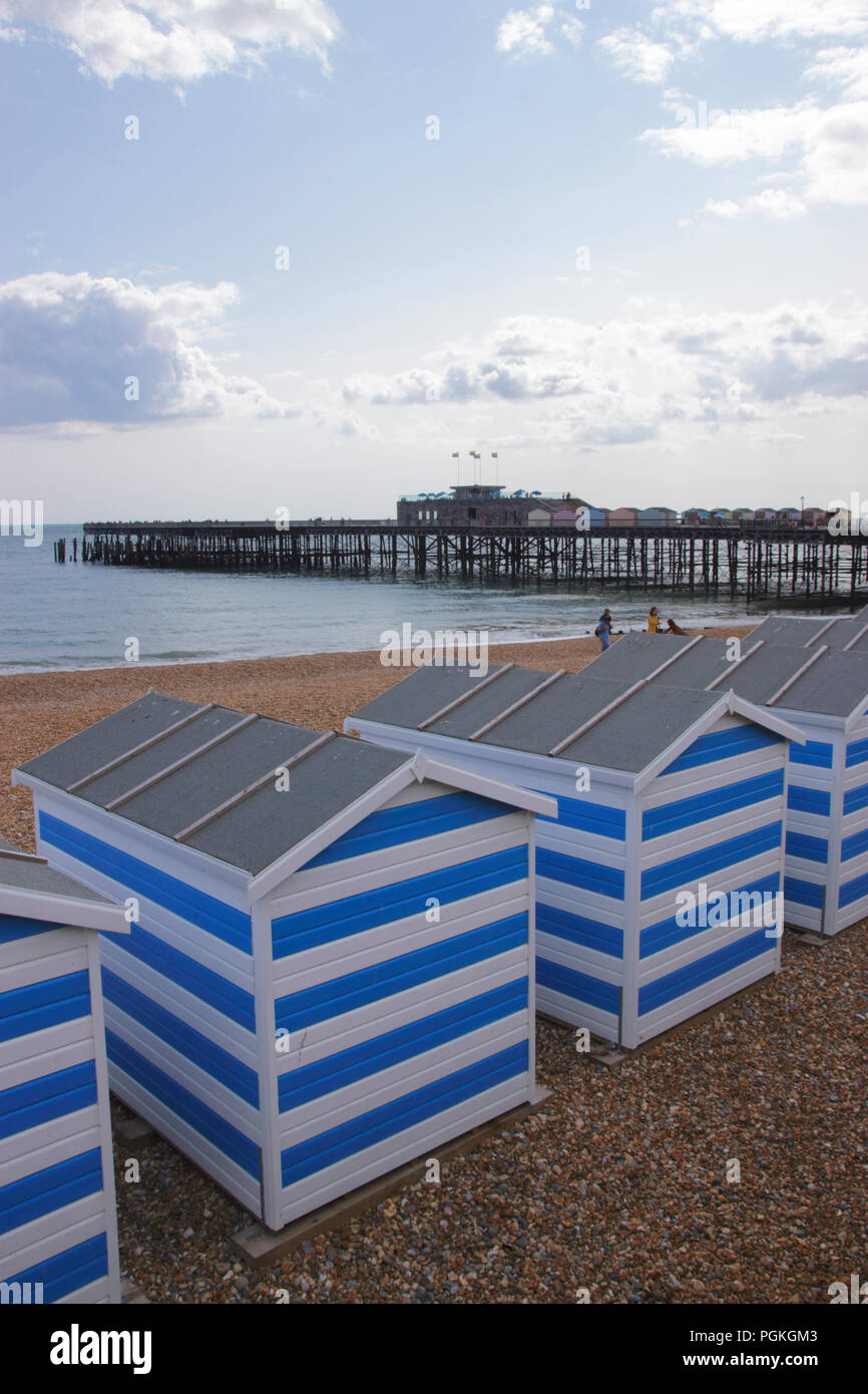 Beach huts and pier Hastings beach East Sussex Stock Photo