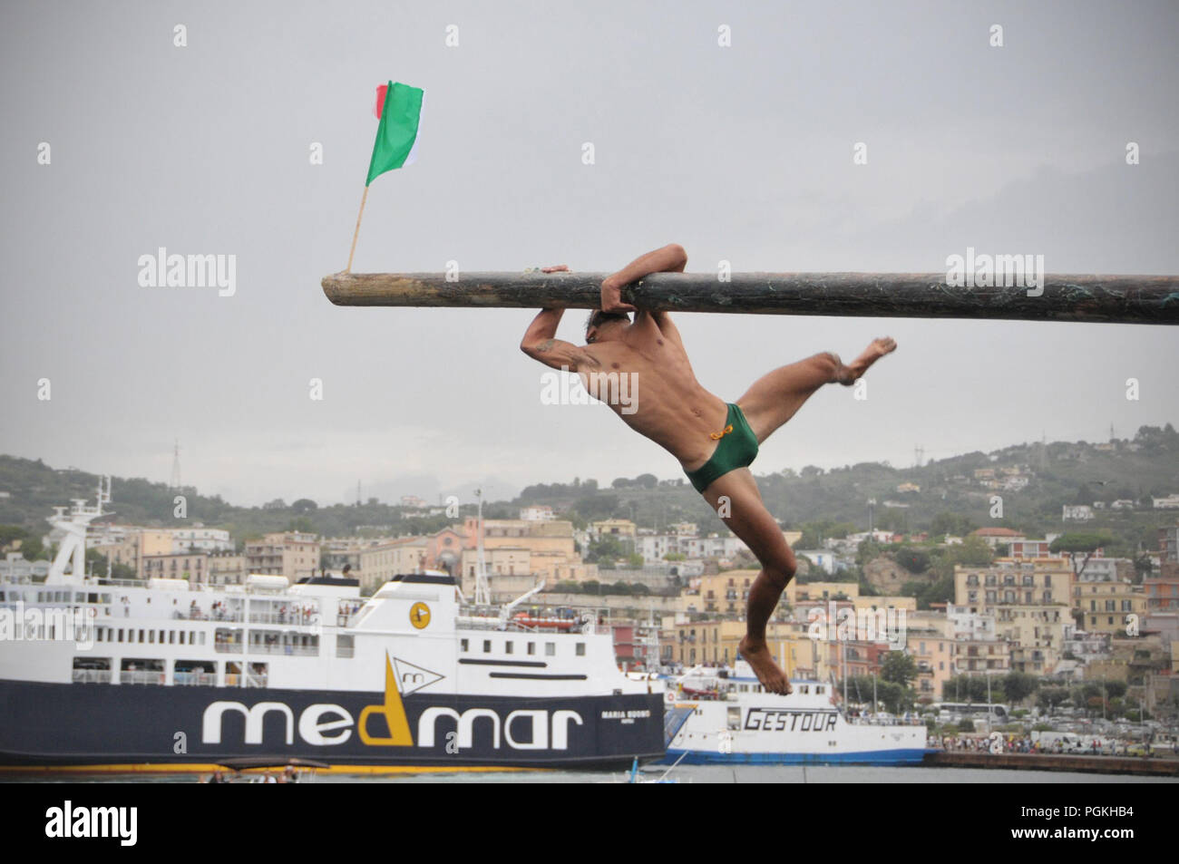 Pozzuoli, Italy. 26th Aug, 2018. The Pennone a Mare is a traditional competition that takes place between the fishermen of Pozzuoli on the Molo Caligoliano. The event is that the fishermen in the race must catch three flags fixed in the ends of a pole covered with soap and facing the sea. The race was postponed on August 15 in a sign of proximity to the city of Genoa after the collapse of the Morandi Bridge takes place today August 26th 2018. Credit: Paola Visone/Pacific Press/Alamy Live News Stock Photo