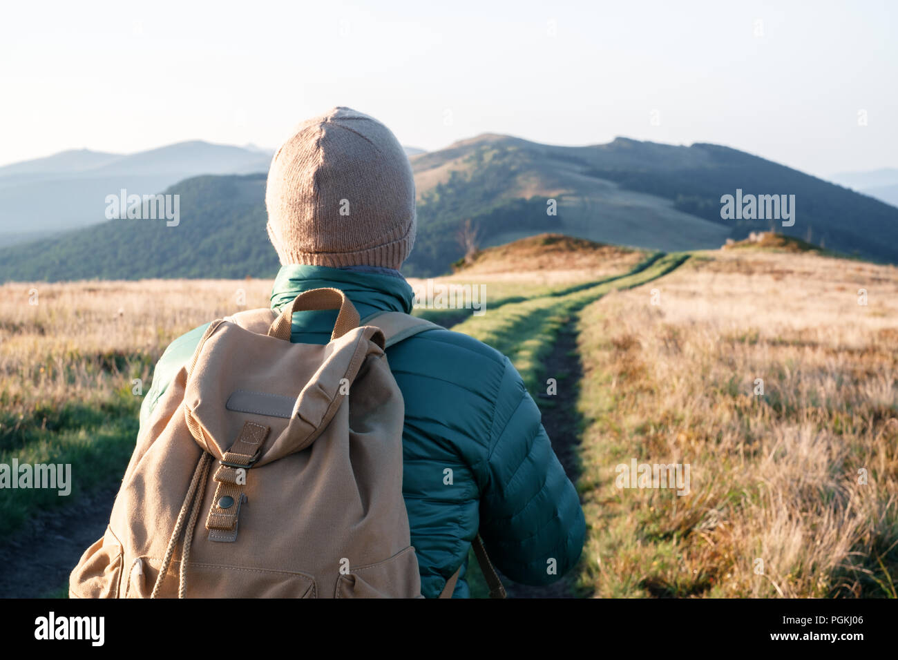 Man with backpack on mountains road Stock Photo