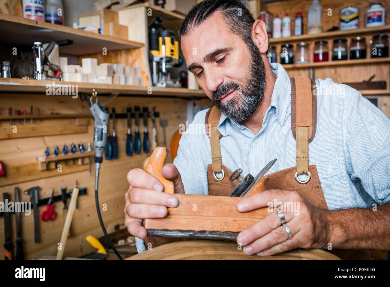 caucasian carpenter at work with planer in a workshop Stock Photo
