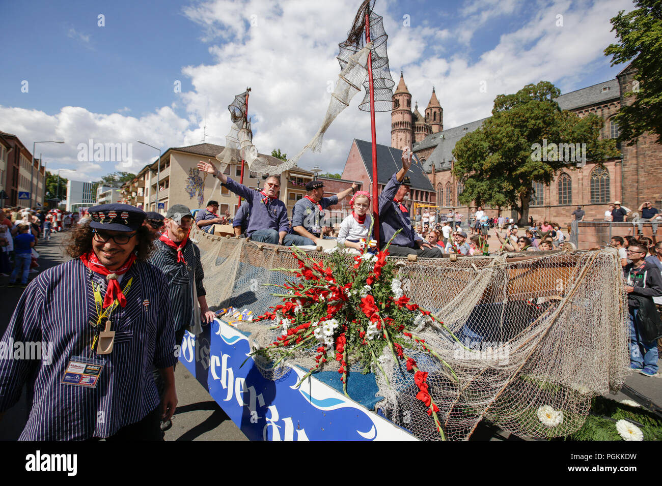 Worms, Germany. 26th Aug, 2018. Members of the old fishermen's guild of Worms ride in a fishing boat in the parade. The first highlight of the 2018 Backfischfest was the big parade through the city of Worms with over 70 groups and floats. Community groups, music groups and businesses from Worms and further afield took part. Credit: Michael Debets/Pacific Press/Alamy Live News Stock Photo