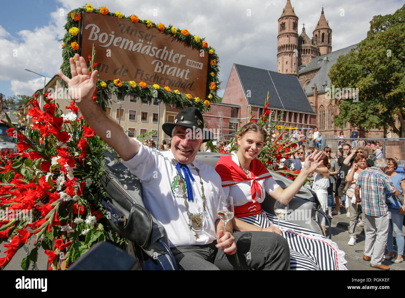 Worms, Germany. 26th Aug, 2018. The Bojemaaschter vun de Fischerwaad (mayor of the fishermen's lea), Markus Trapp, and his bride Beatrice Duda ride in an open horse-drawn carriage in the parade, waving to the crowd. The first highlight of the 2018 Backfischfest was the big parade through the city of Worms with over 70 groups and floats. Community groups, music groups and businesses from Worms and further afield took part. Credit: Michael Debets/Pacific Press/Alamy Live News Stock Photo