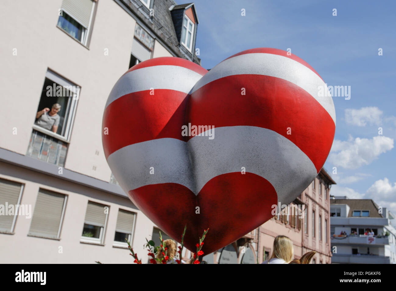 Worms, Germany. 26th Aug, 2018. A giant red and white striped heart, the symbol of the Backfischfest, is on top of a float in the parade. The first highlight of the 2018 Backfischfest was the big parade through the city of Worms with over 70 groups and floats. Community groups, music groups and businesses from Worms and further afield took part. Credit: Michael Debets/Pacific Press/Alamy Live News Stock Photo