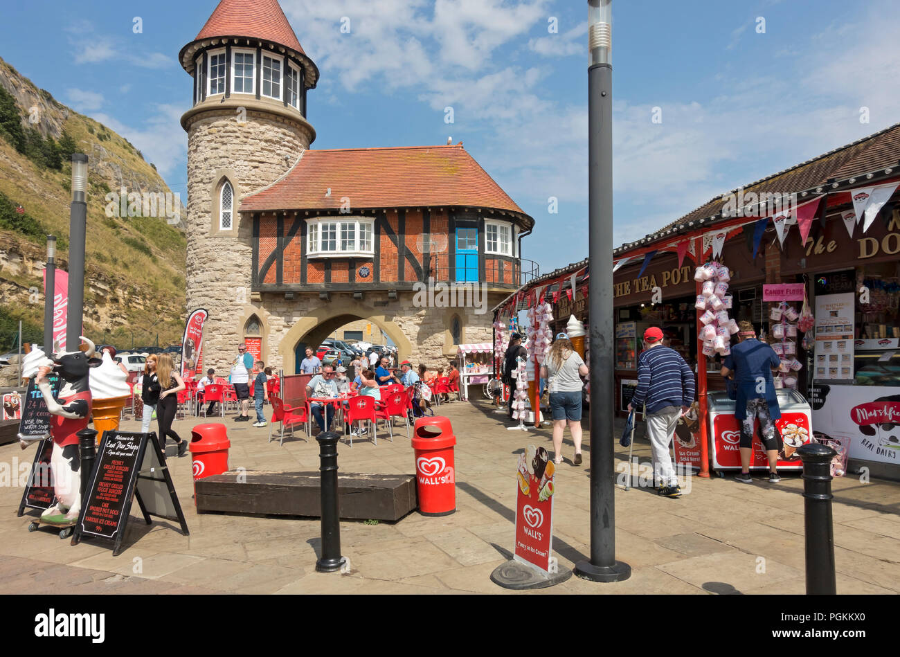 People tourists visitors outside shops and cafes in summer South Toll House Marine Drive Scarborough North Yorkshire England UK United Kingdom Stock Photo